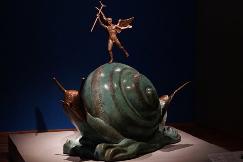Obra de arte pintada y excibida de un caracol que brilla al interior del museo